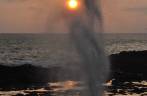 O sol de põe por detrás de um blow hole na costa sul de Kauai, no Havaí